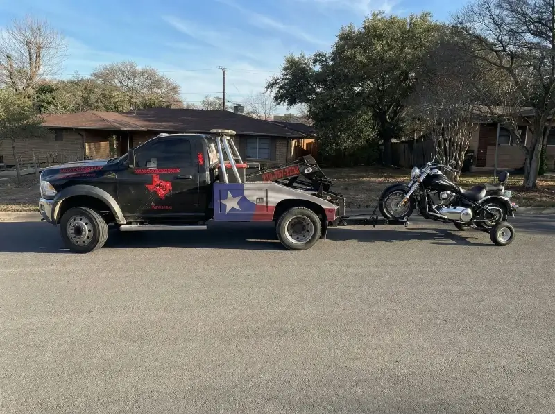 image of a harley davidson motorbike being towed by the truck of texas patriot towing